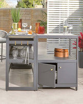 Modern gray outdoor bar cart with shelves, drink storage, and decorative accessories, perfect for entertaining.