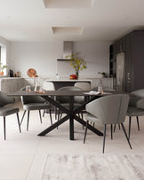 Modern dining room with a rectangular dark wood table and six matching upholstered chairs with slim metal legs. The table exhibits a sleek design with an angular base, while the chairs feature a soft, grey leather-like upholstery for a contemporary look.