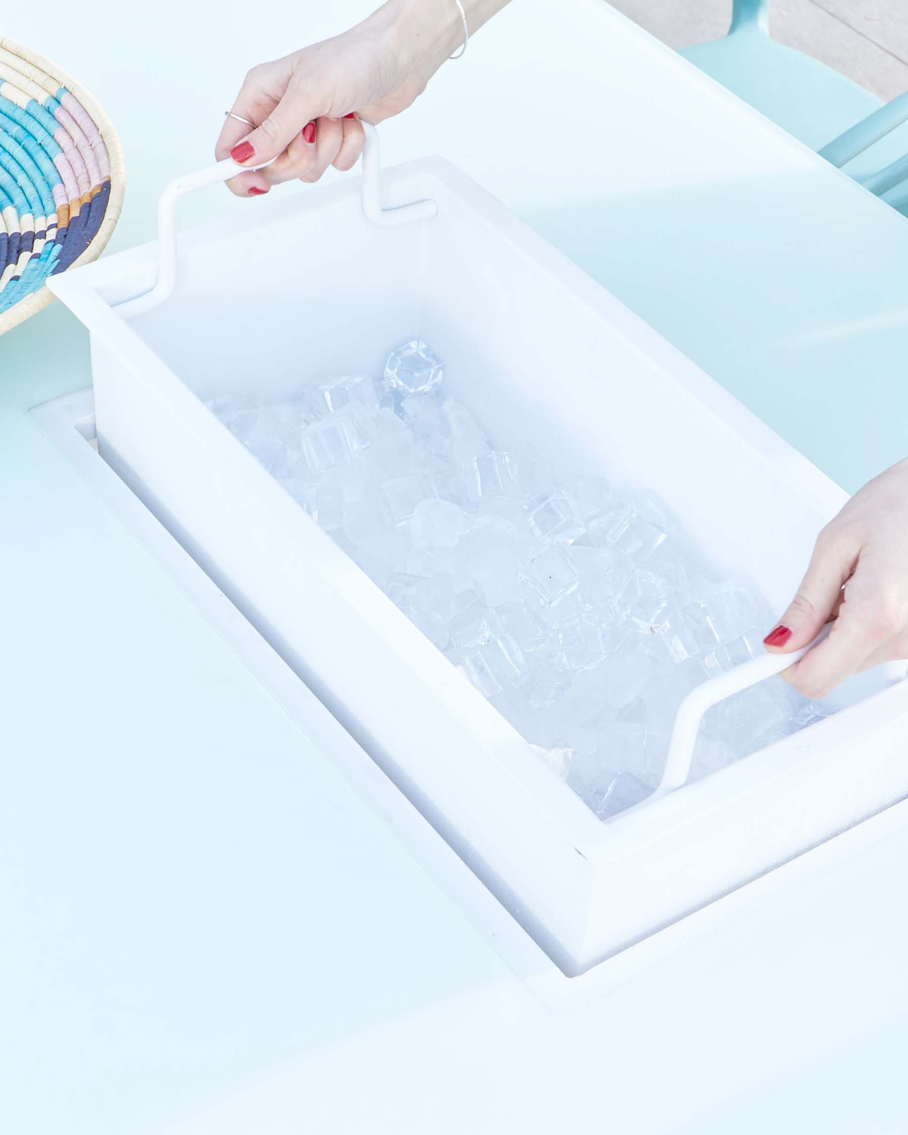 Modern minimalist white ice tray table with clean lines and integrated handles, nested within a sleek pale blue metal frame with a high-gloss finish.