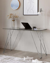 Elegant glass-topped desk with slender, angled metal legs in a contemporary design.