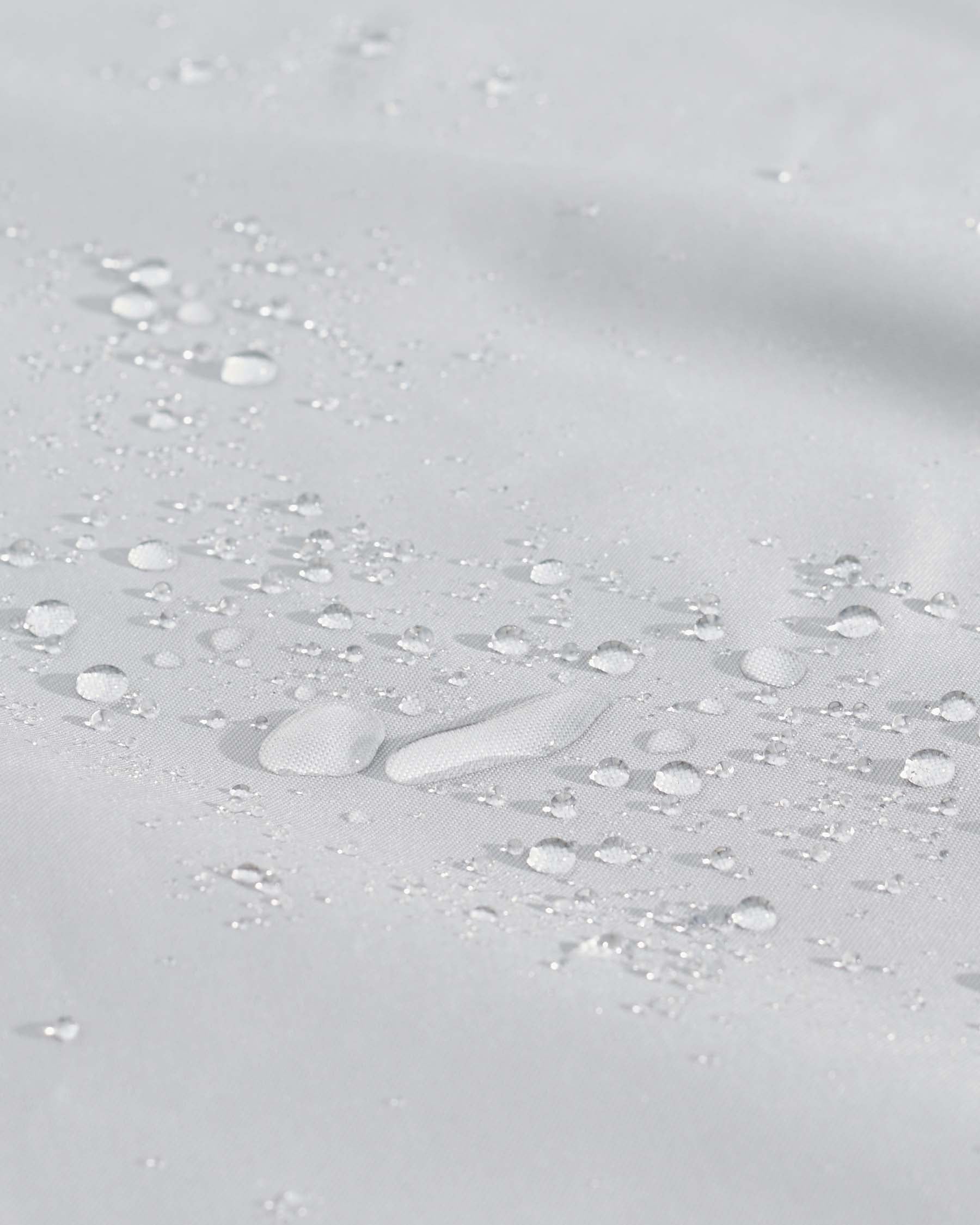 The image provided does not contain any furniture to describe. It appears to be a close-up texture of a water-repellent fabric with scattered water droplets on its surface.