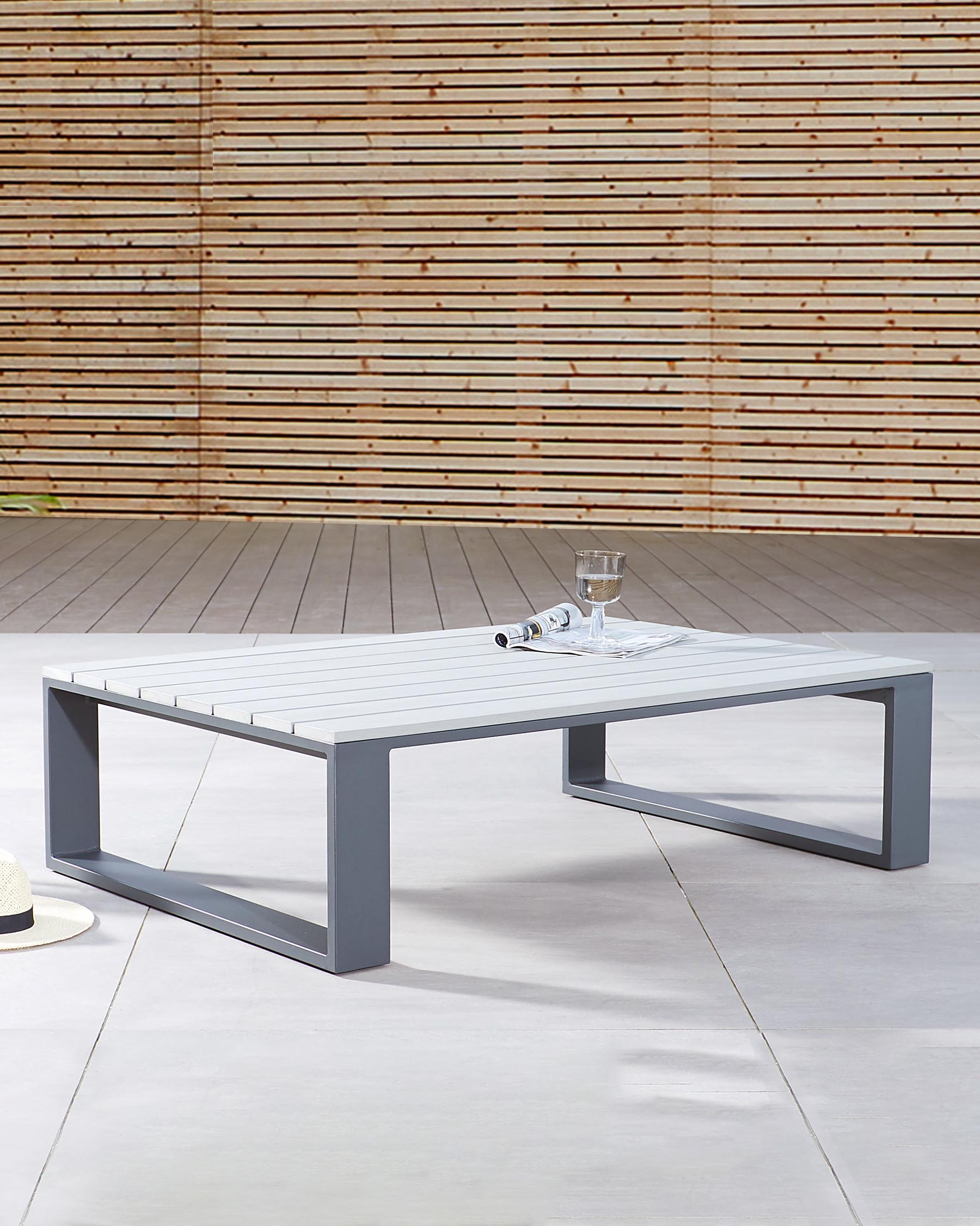 Modern outdoor coffee table featuring a sleek, minimalist design with a rectangular white tabletop and a sturdy grey metal base with a unique geometric frame. Ideal for contemporary patios or garden spaces.