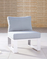 Modern minimalist white-framed single armless chair with light grey cushioning set against a bamboo wall backdrop.