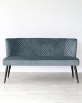 Stylish teal velvet loveseat with a chevron pattern on the backrest and sleek black legs, ideal for modern interiors.