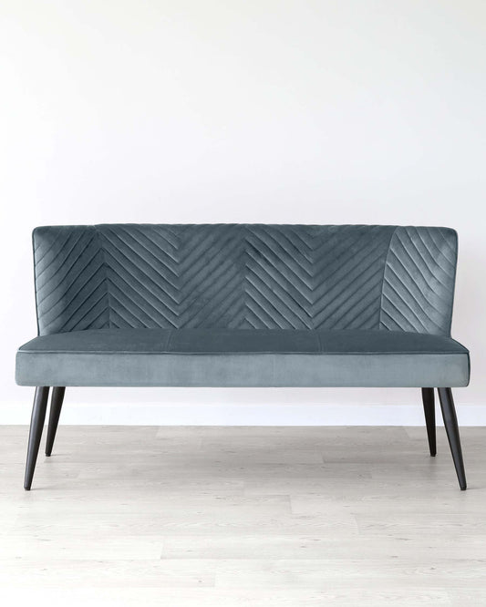 Stylish teal velvet loveseat with a chevron pattern on the backrest and sleek black legs, ideal for modern interiors.