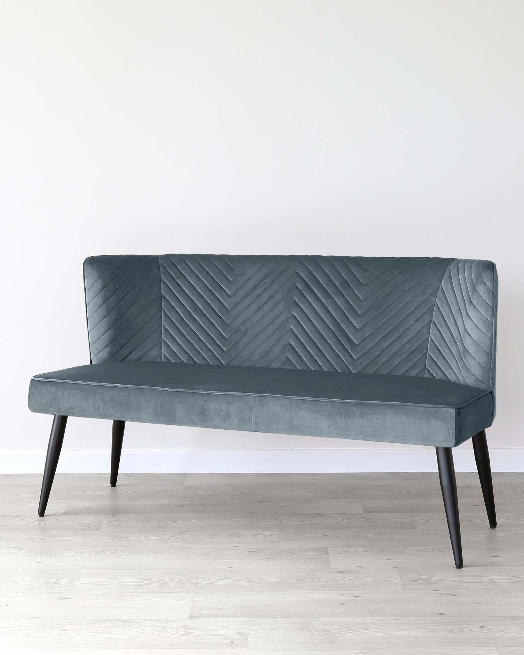 Stylish teal velvet bench with chevron-patterned backrest and sleek black legs, perfect for modern interiors.