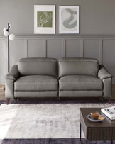 Elegant grey upholstered three-seater sofa with a clean and contemporary design, featuring plush cushions and splayed wooden legs, paired with a modern square wooden coffee table in dark finish, containing a glass teacup and saucer, atop a textured grey and purple area rug.