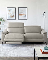 A sleek, light gray reclining sofa with plush cushions, paired with a modern coffee table and decorative art on the wall.