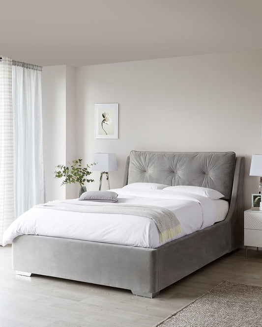 Elegant grey upholstered bed with tufted headboard and matching bed base, complete with white bedding and a light yellow accent pillow.