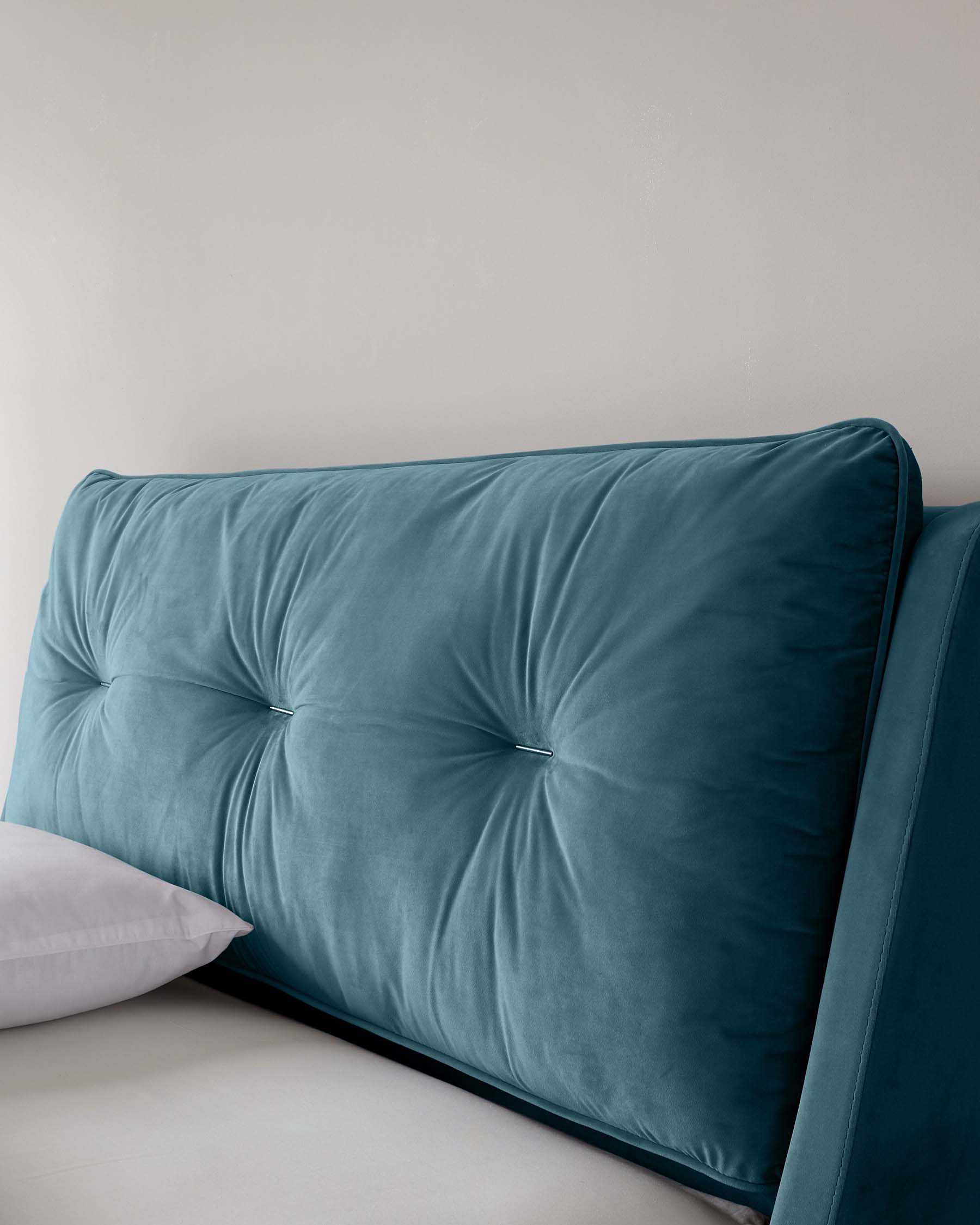 Elegant teal velvet sofa with tufted backrest and cushion, featuring a plush and smooth texture with deep button detailing.