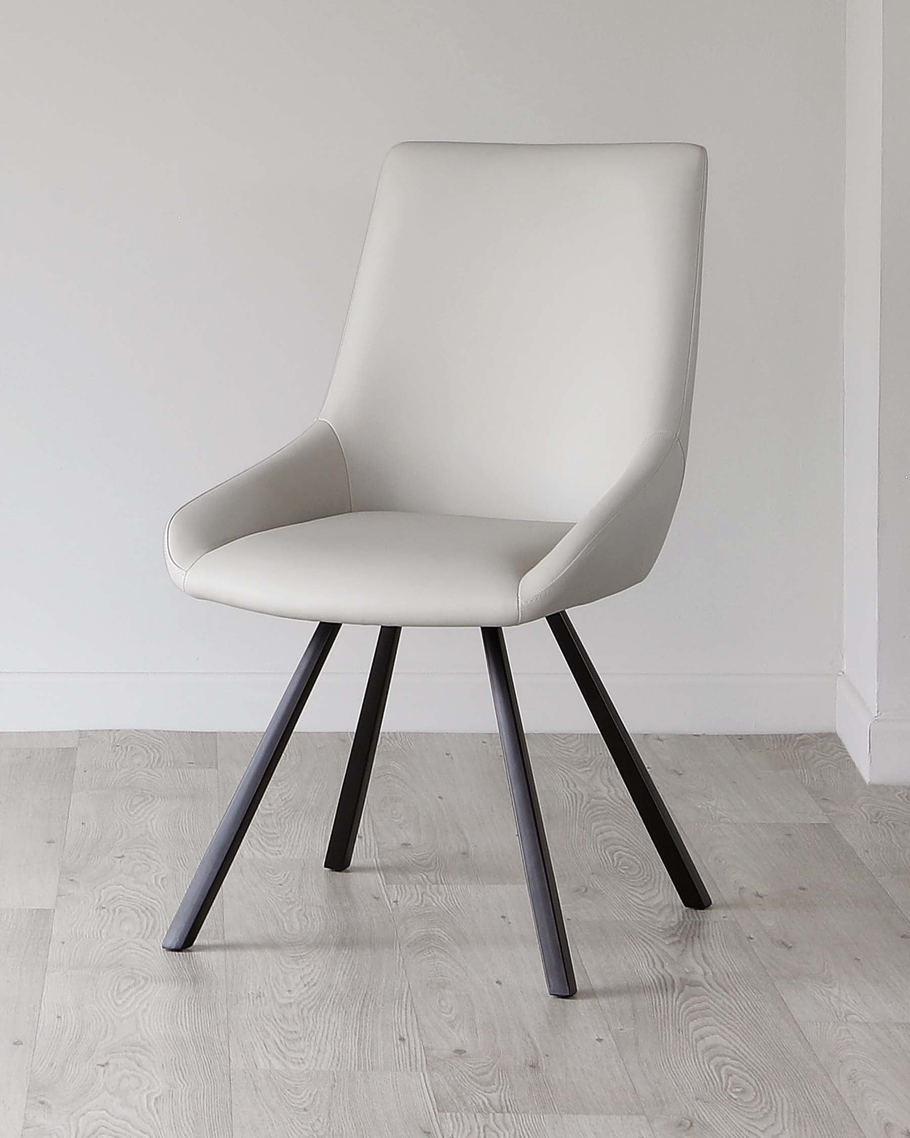 A modern light grey upholstered dining chair with a high backrest and comfortable armrests, featuring sleek black metal legs, set against a minimalist background with light wood flooring.