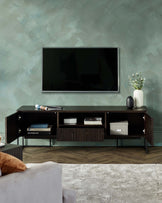 Modern TV stand with open and closed storage, featuring sleek lines, dark wood finish, and minimalist decor accents.