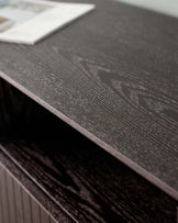 Elegant dark wood furniture with a textured surface, featuring an open shelf and a sleek, modern design.