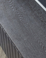 Close-up of a contemporary dark wood textured table edge and surface with distinctive wood grain patterns.