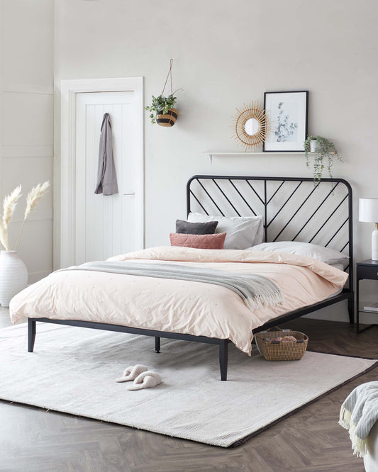 A contemporary black metal bed frame with a minimalist headboard design, complemented by an off-white textured area rug beneath it.